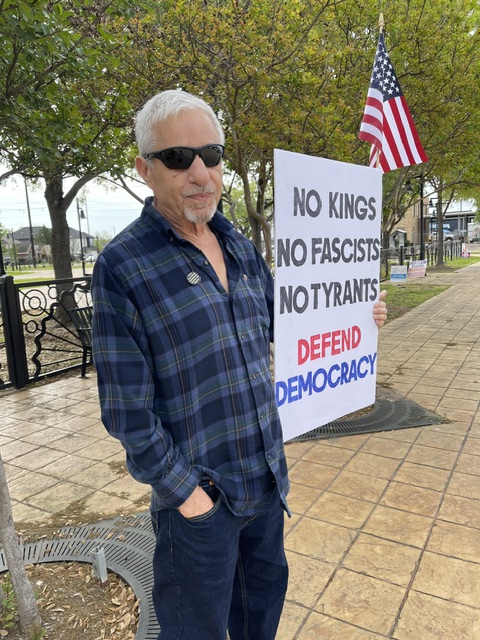 Mike holding sign that reads "No Kings, No Fascists, No Tyrants: Defend Democracy."